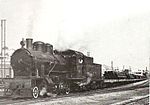 A 1050mm gauge 2-8-0 steam locomotive pulls a train of construction materials on the Palestine Railways in 1946