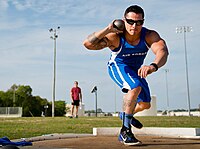 A shot putter performs an isometric press by applying downward pressure onto his bent right leg. This will allow him to turn and spring forwards more powerfully, and channel the muscular force generated by the press into the throw.