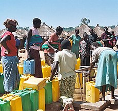 Las mujeres se alinean en un prospección para llenar sus contenedores con agua (Campo de refugiados Labuje, Kitgum, Distrito de Kitgum, Región Norte de Uganda)