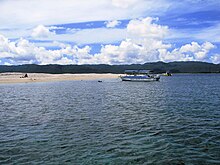 Small boats near the coast of a sandy islet