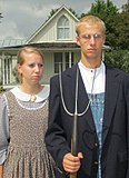 Visitors wearing period-style clothing, and with props such as a pitchfork and glasses