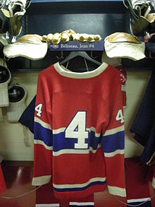 Photographie du maillot rouge des Canadiens accroché dans le vestiaire avec le numéro 4 écrit dessus