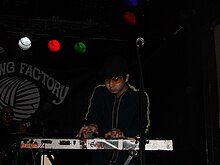 A picture of a man playing the keyboard with yellow glasses.