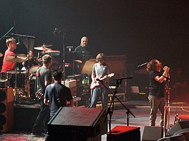 Pearl Jam performing on stage in 2009; the band is arranged in a semi-circle behind singer Eddie Vedder