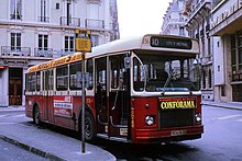 Photographie en couleurs d’un autobus rouge et crème.