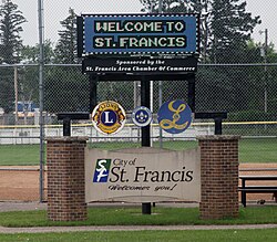 Electronic welcome sign above a brick and concrete sign saying City of St. Francis Welcomes You!