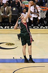 Andrew Bogut lunges toward a rebound while playing for the NBA's Milwaukee Bucks.