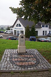 Ganzmeilenstein mit der Aufschrift: »Zwickau 2,00 M.« an einem gepflasterten Sachsen-Wappen am Straßenrand