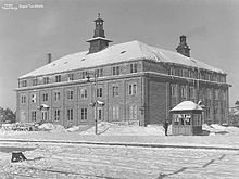 Square, three-story hotel in winter