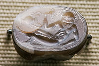 Engraved gem of a reclining satyr, Etruscan c. 550 BC, 2.2 cm wide. Note the vase shown "sideways"; it is characteristic of early gems that not all elements in the design are read from the same direction of view.
