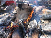 A traditional billycan on a campfire, used to heat water, typically for brewing tea
