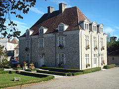 Photo d'un bâtiment de deux étages aux balcons fleuris.