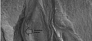 Close-up of gullies, as seen by HiRISE under HiWish program. Arrow points to streamlined features. This enlarged view shows an excellent view of polygons which are common where ice-rich ground freezes and thaws.