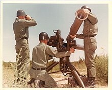 Three soldiers set up a BGM-71 TOW antitank missile launcher.