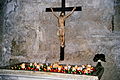 A crucifix in a church, with votive candles.
