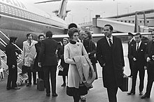 Photographie en noir et blanc d'un groupe de personnes devant un avion.