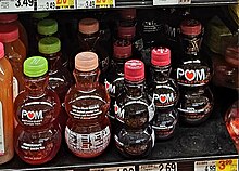 Grocery store shelf with bottles of dark juice