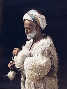 A man from Ramallah spinning wool. Hand-tinted photograph from 1919, restored.