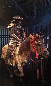A re-creation of an armored samurai riding a horse, showing horse armour (uma yoroi or bagai)