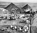 Au premier plan, une cité ouvrière. Derrière, l'usine de distillation, la raffinerie et les deux terrils coniques.