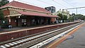 Southbound view from Platform 2, showing station building on Platform 1, April 2022