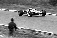 Black and white photo of Jim Clark driving a car on a race track