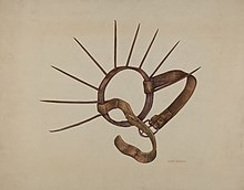 A ring with long metal spikes and two leather straps.