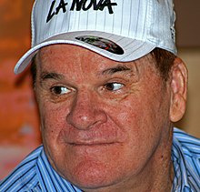 A wide-faced man wearing a white baseball cap