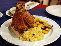 Schweinshaxe served with fried potatoes and sauerkraut at a restaurant in Thailand