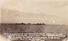 The sepia-toned photo shows a calm sea with the silhouettes of three ships on the horizon. Two ships are positioned bow-to-bow, with the third one perpendicular between them. The sun is low on the horizon to the right. At the bottom, there is an inscription in white capital letters: "SCENE OF SURRENDER OF BOLSHEVIKS' DESTROYER SPORTAK TO HMS CALYPSO AND DESTROYERS, AFTER A SHORT FIGHT. KASKOL KASKOLNIKOW THE NOTORIOUS BOLSHEVIK LEADER AND CREW ABOARD CALYPSO AS PRISONER". Below this is the date "DEC. 26. 1919".