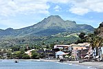 Waterfront village with volcanic mountain in the background.