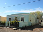 Flat roofed house with parapet wall and moulded ledge work across the facade. Fenestration is geomet Architectural style: Vernacular. Previous use: Residential. Current use: Residential.