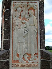 Monument de la Vierge Marie, scène du retour des prisonniers symbolisée par les membres d'une famille accueillis par la Vierge Marie.