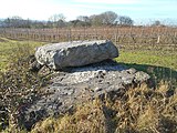 The Coffin Stone visible underneath another slab