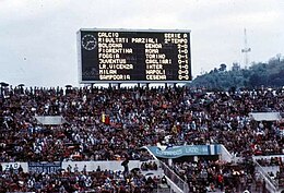 A large scoreboard above a large grandstand