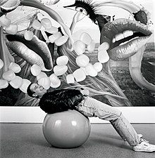 Jeff Koons lying on gymnastic ball in front of one of the Easyfun paintings.
