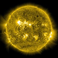 The sun in orange, as seen from the visible spectrum, with Venus in the top left quadrant