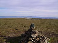 Cairn on the north top of Stybarrow Dodd incorporating the slate marker. Beyond is the intermittent pool, and the remains of the wall