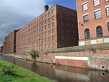 Photoraphie. Manufactures en brique« La masse rectangulaire de grandes usines aux multiples fenêtres… » Ancoats'Mills (Murray's Mills aujourd'hui[N 16]).