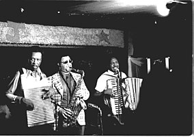 Chenier Brothers performing at Jay's Lounge and Cockpit, Cankton, Louisiana, Mardi Gras, 1975 Clifton Chenier on accordion, brother Cleveland on washboard and John Hart on tenor saxophone.