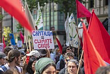 Placard saying "capitalism equals climate crisis" at a demonstration.
