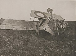 Photo noir et blanc de militaires posant devant une carcasse d'avion.