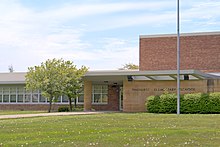 Photograph of a low-slung, sandstone and red colored brick school building