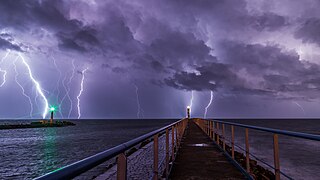 Port and lighthouse overnight storm with lightning in Port-la-Nouvelle