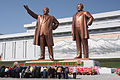 צפון-קוריאניים משתחווים לפני הפסלים של הדיקטטורים קים ג'ונג-איל (מימין) ואביו קים איל-סונג (משמאל) באנדרטה הגדולה בגבעת מאנסו שבפיונגיאנג