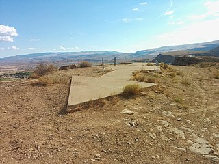 A remnant of transcontinental airmail, Route Beacon 37A, which was located atop a bluff in St. George, Utah, U.S., with concrete arrows indicating the direction to the next beacon, a rotating light tower, and a shed that usually held a generator and fuel tanks. These beacons were once situated every 10 miles on air routes across the United States beginning around 1923.