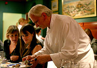A chef preparing a truffle for diners