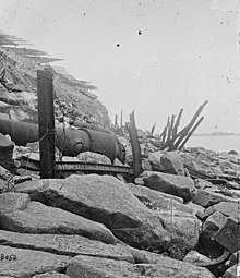 Exterior view of Fort Sumter, 1865. Banded rifle in foreground, fraise at top.