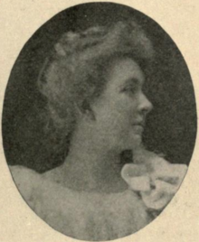 A white woman with blond hair in an updo, photographed in profile