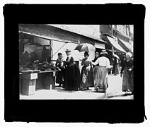 Étal de marchande de légumes devant le no 16 (photographie sur verre de Georges Ancely, 1894).